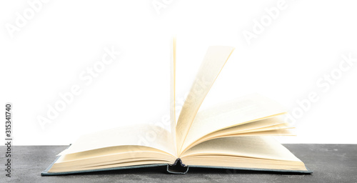 Open book on grey stone table against white background