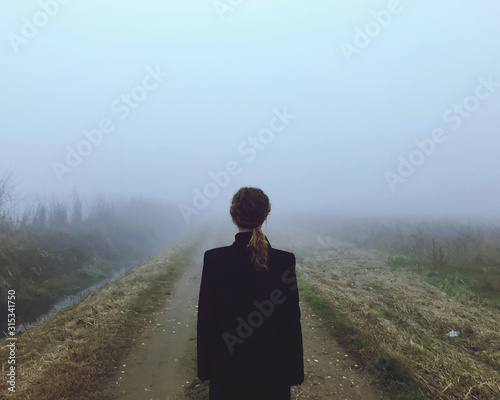 Una donna pensierosa nella nebbia nella ricerca di felicità  photo