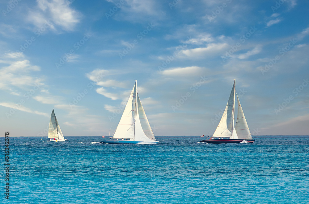 Three sailboats on the horizon in the ocean