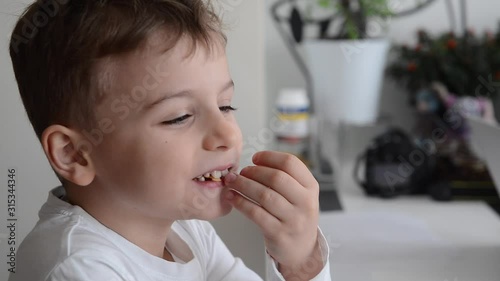 happy child boy eating potatoes chips and laughing