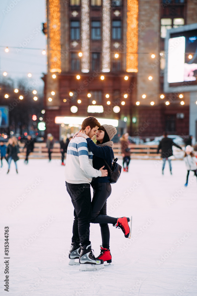 Young couple skates at the rink and embraces. Young couple skates at the rink and embraces.