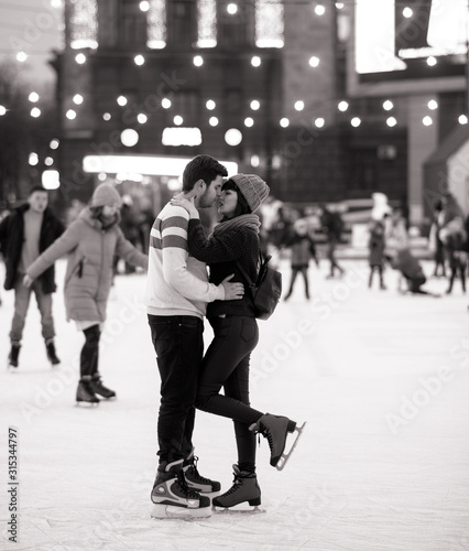 Young couple skates at the rink and embraces.