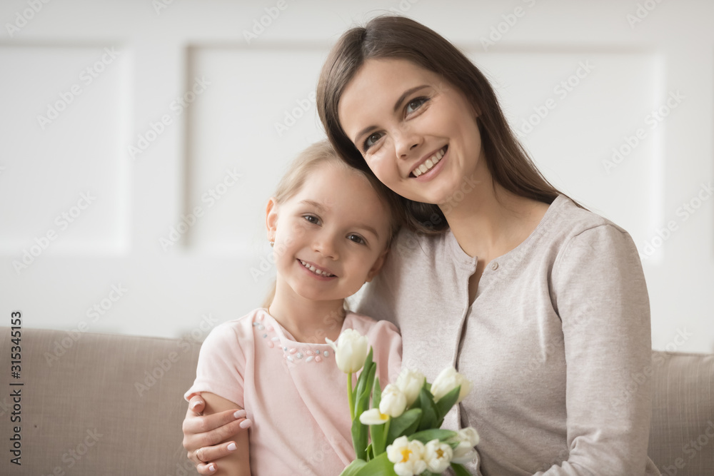 Head shot portrait mother and daughter with bouquet of flowers Head shot portrait mother and daughter with bouquet of flowers