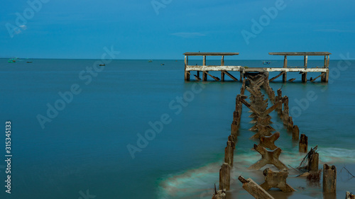 Dilapidated old fishing dock collapsing into the sea in Pak Nam Pran Thailand photo