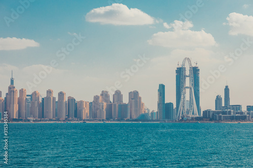 Obraz na płótnie Skyline view of Dubai with palms and skyscraperst. Sunny summer day in Dubai desert. Dubai is the most famous tourist destination in UAE. Ideal place for luxury travel. Creative retro toned image w salonie