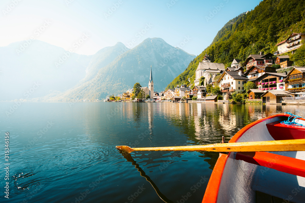 Classic view of Hallstatt with traditional rowing boat in summer, Salzkammergut region, Austria