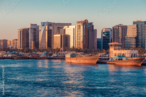 Skyline view of Dubai Creek with skyscrapers, traditional boats and piers. Dubai is the most famous tourist destination in UAE. Mix of modern and retro lifestyle in Dubai. Creative retro color toning