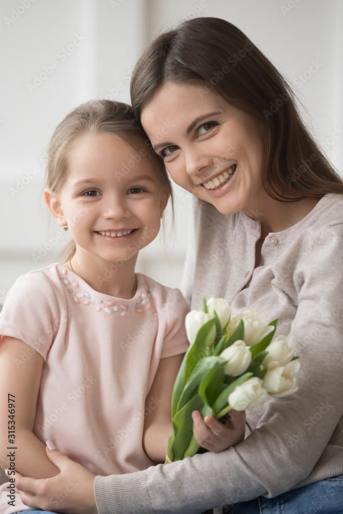 Head shot portrait mother and little daughter with flowers vertical Head shot portrait mother and little daughter with flowers vertical