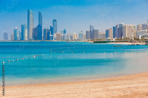 Cityscape panorama of Abu Dhabi downtown with sea, sand beach and skyscrapers. Sunny summer day in Abu Dhabi. Famous tourist destination in UAE. Ideal place for luxury travel, shopping and rest © oleg_p_100