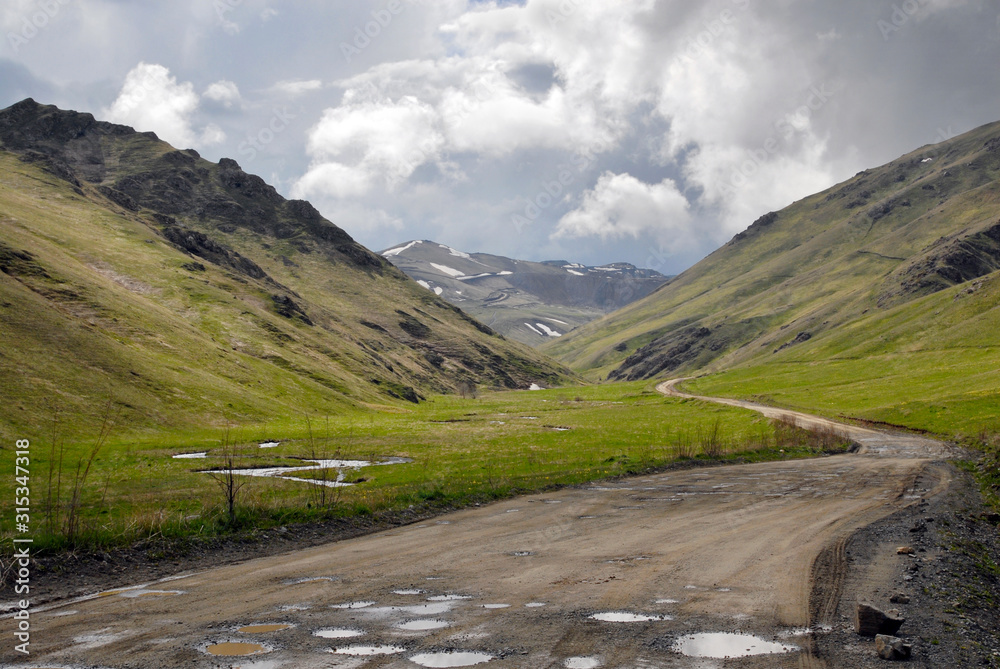 Road with puddles. Zodk (Sotk) Pass, Armenia and Mountainous Karabakh.