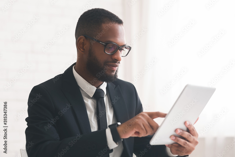 Young modern businessman using tablet in office Young modern businessman using tablet in office