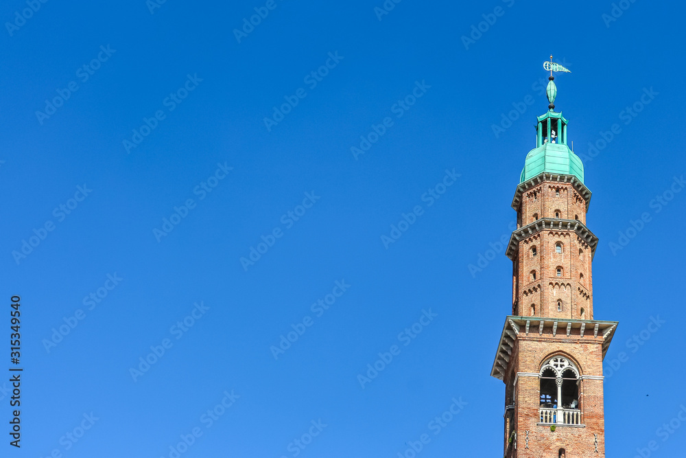 Fototapeta premium Vicenza, Włochy. Widok na wieżę zegarową (Torre Bissara) na słynnym placu (Piazza dei Signori) w Vicenzy.