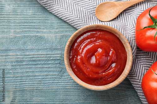 Tasty tomato sauce on blue wooden table, flat lay. Space for text