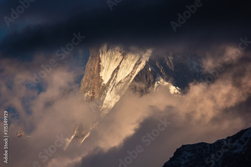 Clouds cover the snow capped peak of Machapuchare aka the Fish Tail mountain on the Annapurna Base Camp trail in the Nepal Himalaya. © Balaji