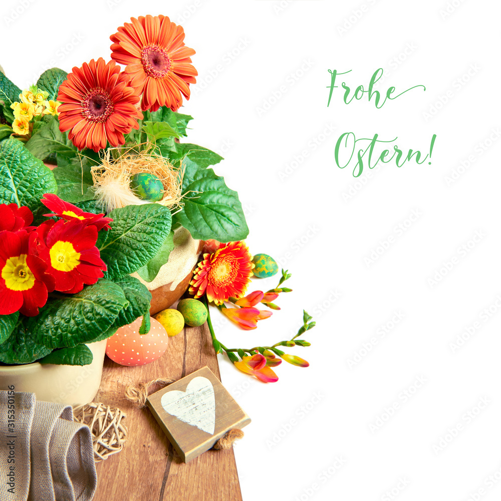 Easter border with orange gerbera, freesia flowers and natural zero waste eco friendly Spring decorations. Frohe Ostern means Happy Easter in German. Isolated on white, text space