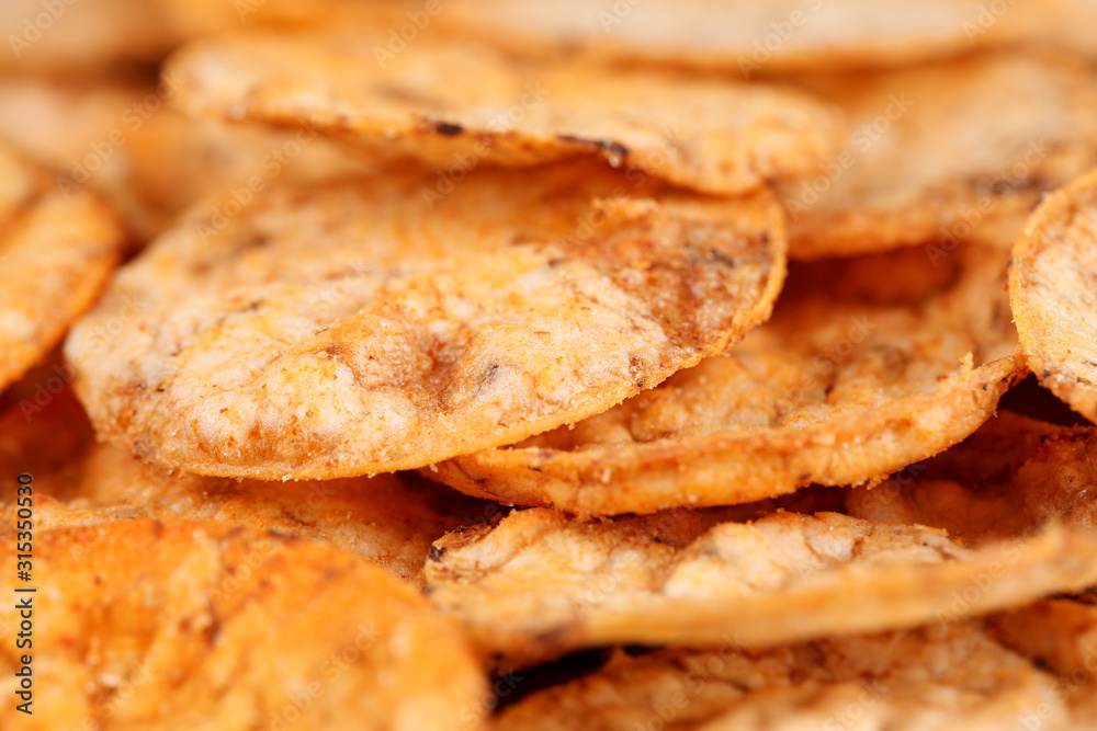 Extreme close up of a pile of organic, crispy, baked, whole grain rice chips with tomato and paprika spices. Gluten free healthy snack. Macro food background, selective focus Extreme close up of a pile of organic, crispy, baked, whole grain rice chips with tomato and paprika spices. Gluten free healthy snack. Macro food background, selective focus