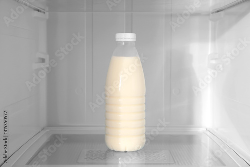 Bottle of milk on shelf inside modern refrigerator