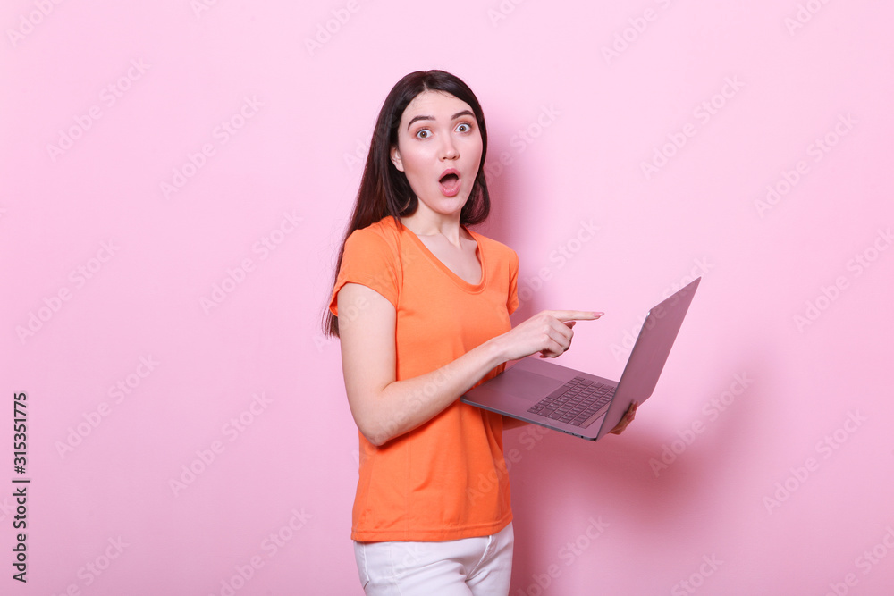 girl holds a modern laptop on a colored background. girl holds a modern laptop on a colored background.