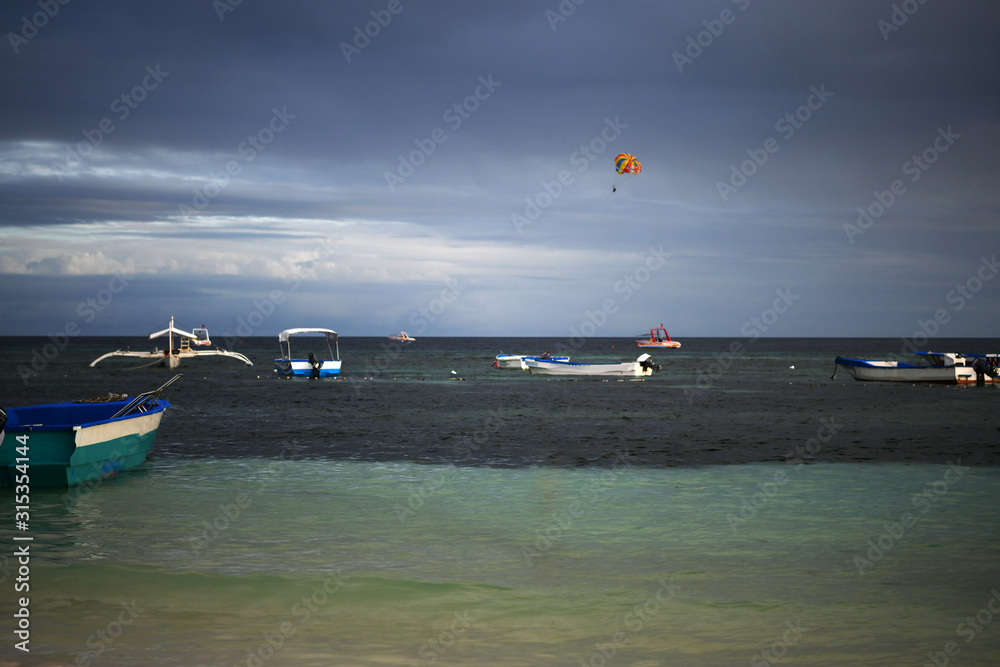 Obraz premium fishing and tourist boats near the shore at sunset on a tropical island