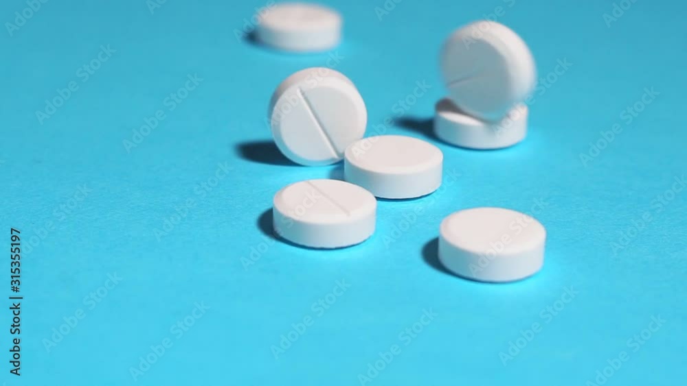 white pills on a blue background close up white pills on a blue background close up