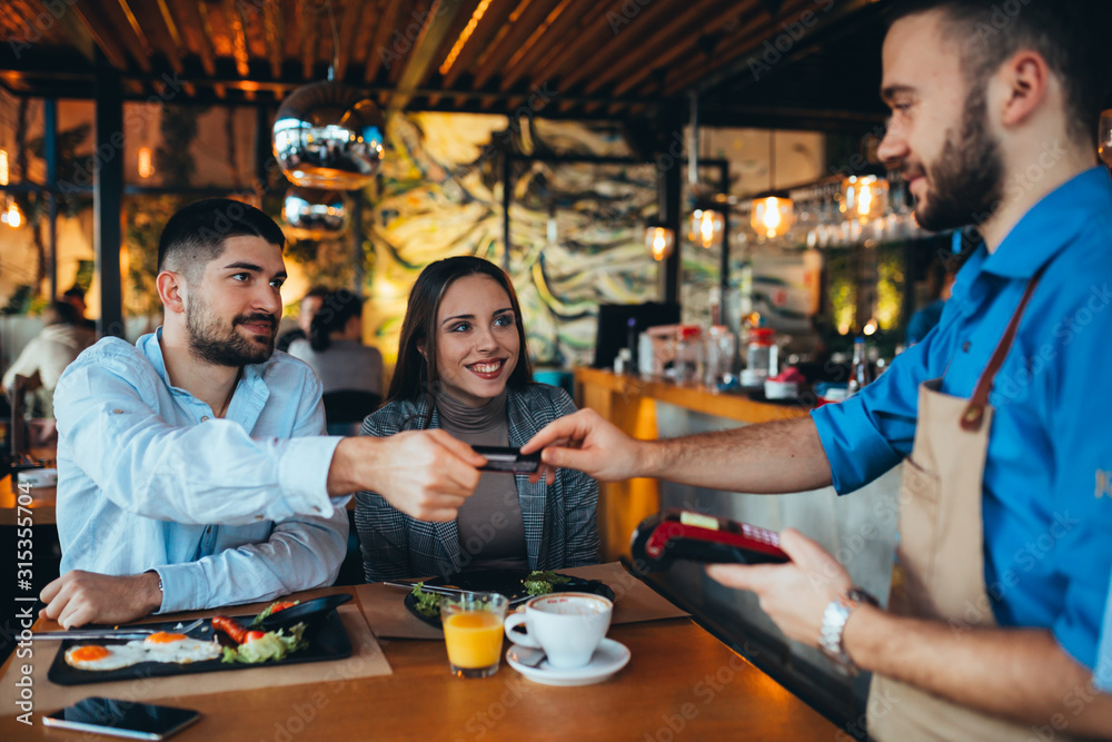 man paying bill using credit or debit card