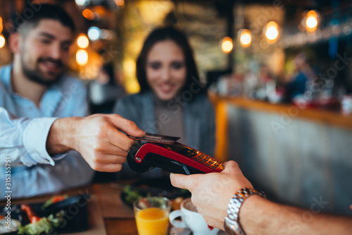 фотографія close up of man paying bill using credit or debit card