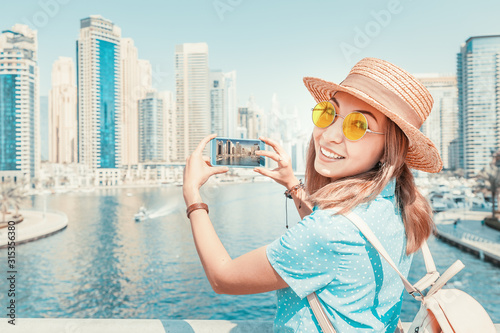 Photography Happy Asian tourist girl taking photos in popular Marina district in Dubai for h