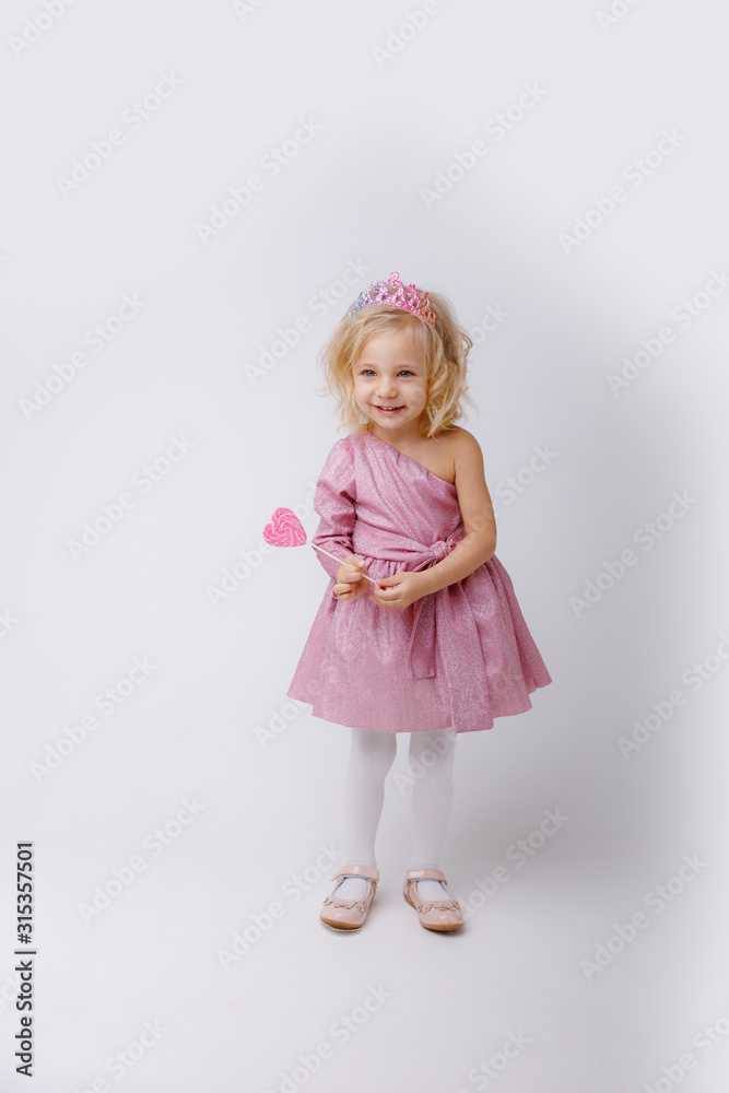 beautiful little blonde girl with a heart shaped Lollipop.valentine's day