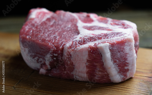 raw pork neck steak on a wooden board