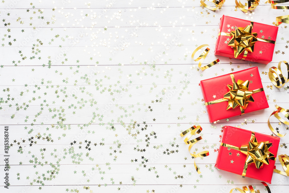 Gift boxes with gold ribbons and bows, confetti stars on a white background. Copy space Flat lay. Greeting card for birthday party, Christmas Wedding mother's Day. Gift boxes with gold ribbons and bows, confetti stars on a white background. Copy space Flat lay. Greeting card for birthday party, Christmas Wedding mother's Day.