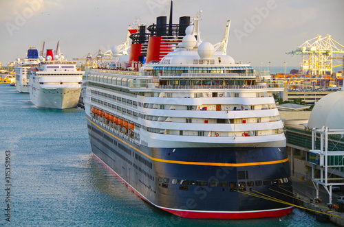 Cruiseships  or cruise ship liners Disney Cruise, Carnival and NCL Norwegian line up in port of Miami during sunset for departure on Caribbean cruises dream vacation