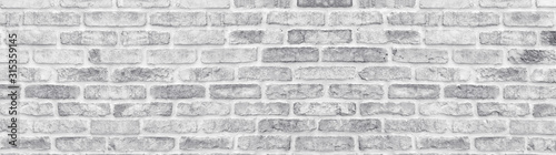 White washed shabby brick wall wide texture. Large light gray rustic brickwor...