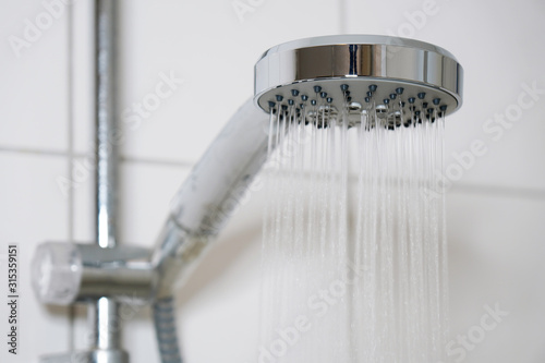 Картината върху платно shower with modern showerhead and running water in domestic bathroom close-up
