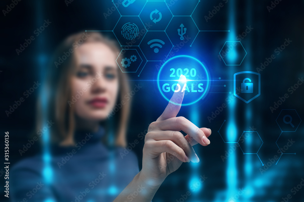 Business, Technology, Internet and network concept. Young businessman working on a virtual screen of the future and sees the inscription: 2020 goals Business, Technology, Internet and network concept. Young businessman working on a virtual screen of the future and sees the inscription: 2020 goals