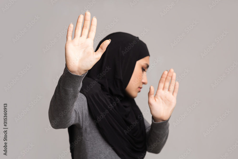 Afraid arabic girl showing stop gesture, protecting herself from violence Afraid arabic girl showing stop gesture, protecting herself from violence