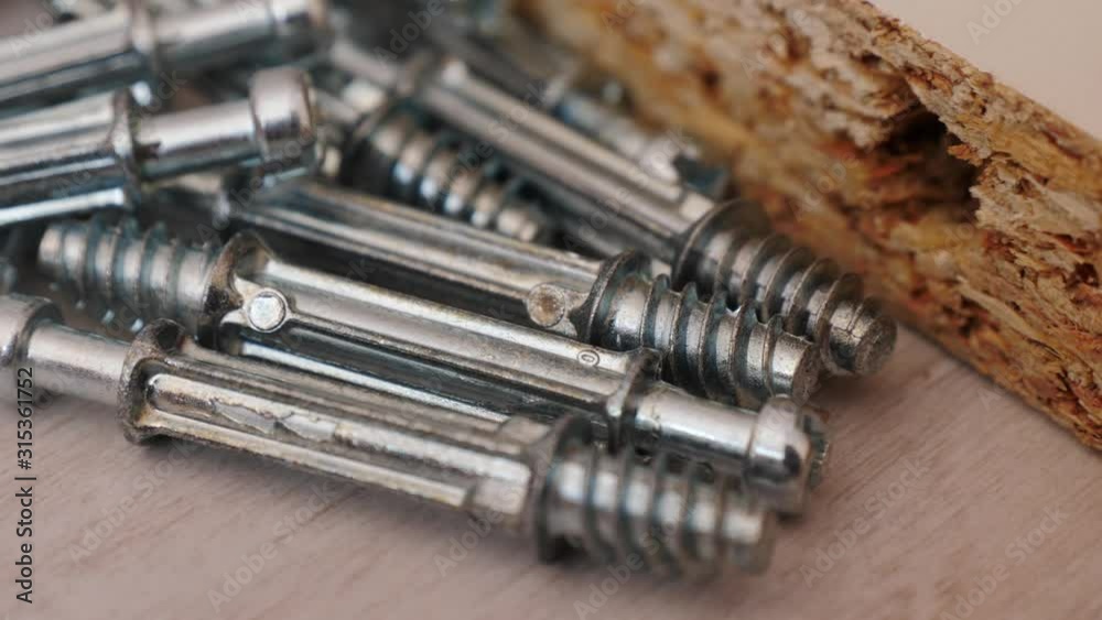 Assembling furniture at home. Many mounting screws and board on floor. Do it yourself furniture assembly Assembling furniture at home. Many mounting screws and board on floor. Do it yourself furniture assembly