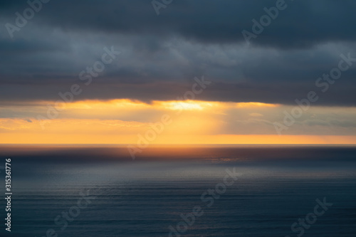 Aerial view of low clouds over Tasman sea at Piha in sunset light © Emagnetic