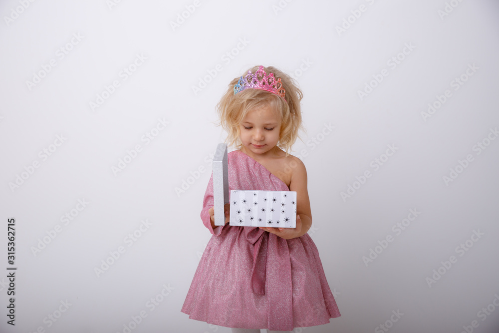 cute little girl in a princess dress with a crown holding a gift on a white background cute little girl in a princess dress with a crown holding a gift on a white background