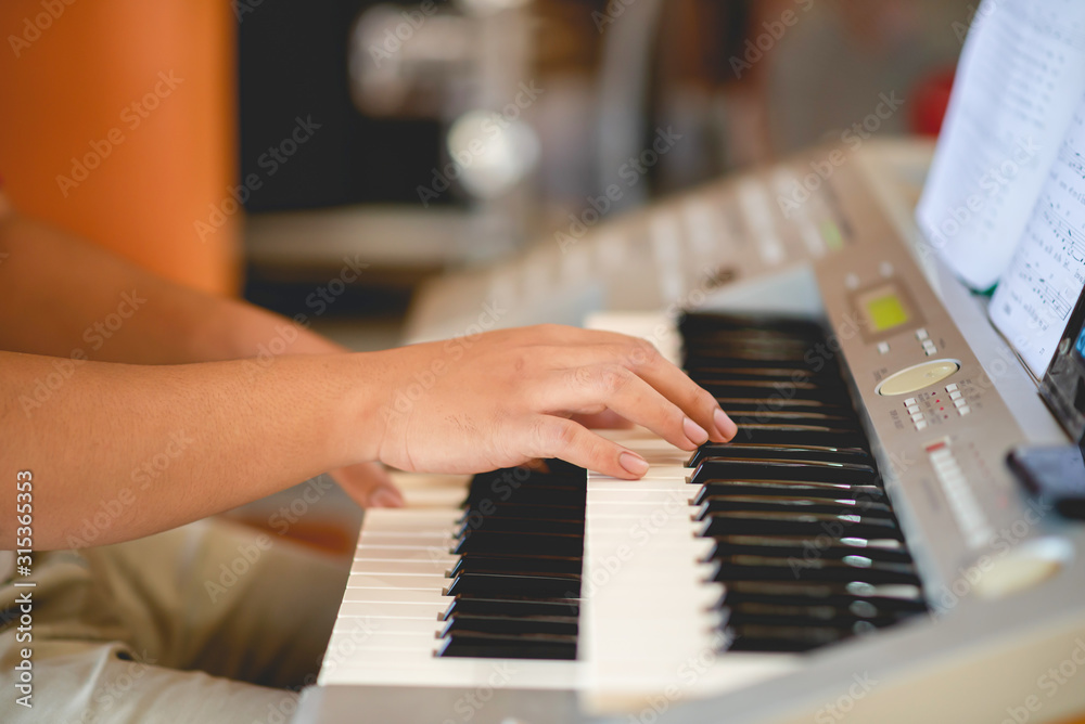 Obraz premium Close-up of a music performer's hand playing the piano