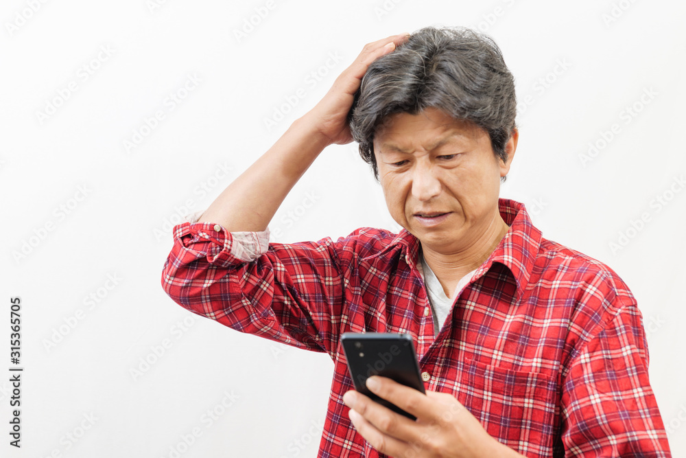 スマートフォンを見て困った顔をする男性 スマートフォンを見て困った顔をする男性