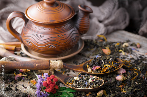 Dry tea leaves on a table in a composition with accessories for tea drinking