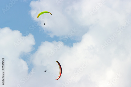 A group of sportsmen flies in the sky in a professional suit on a paraglider. Paragliding Sport Concept for advertising