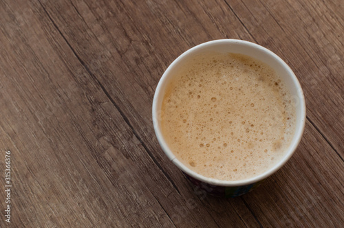 Cappuccino with a delicious foam in a paper cup, top view, coffee to go