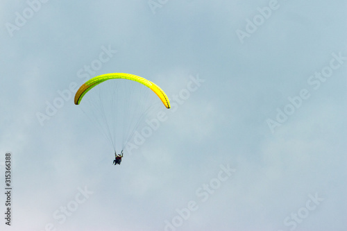 A sportsman flies in the sky in a good suit on a paraglider. Paragliding Sport Concept