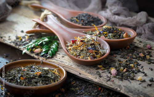 Dry tea leaves on a table in a composition with accessories for tea drinking