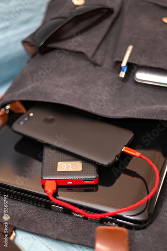 Smartphone charging of a power bank out of a shoulder bag © bymandesigns