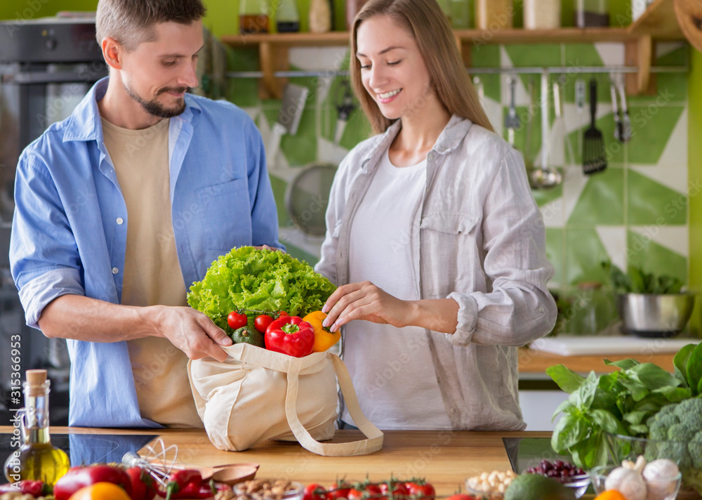 Young vegetarian couple in love preparing dinner with vegetables Young vegetarian couple in love preparing dinner with vegetables