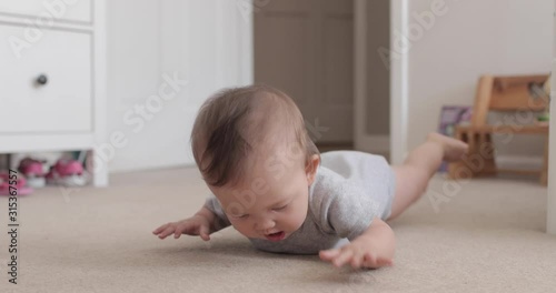 Baby Laying of Floor Trying to Learn How to Crawl