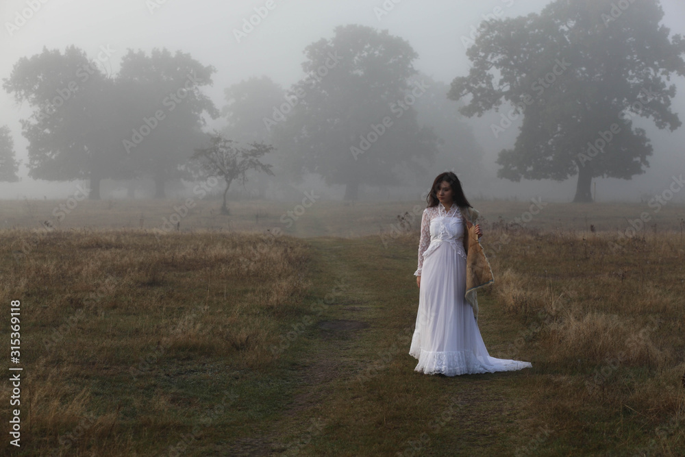girl in a white dress on a mist field with oaks girl in a white dress on a mist field with oaks
