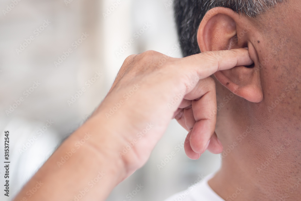 man picking his ear with nasty dirty habit concept of ear wax